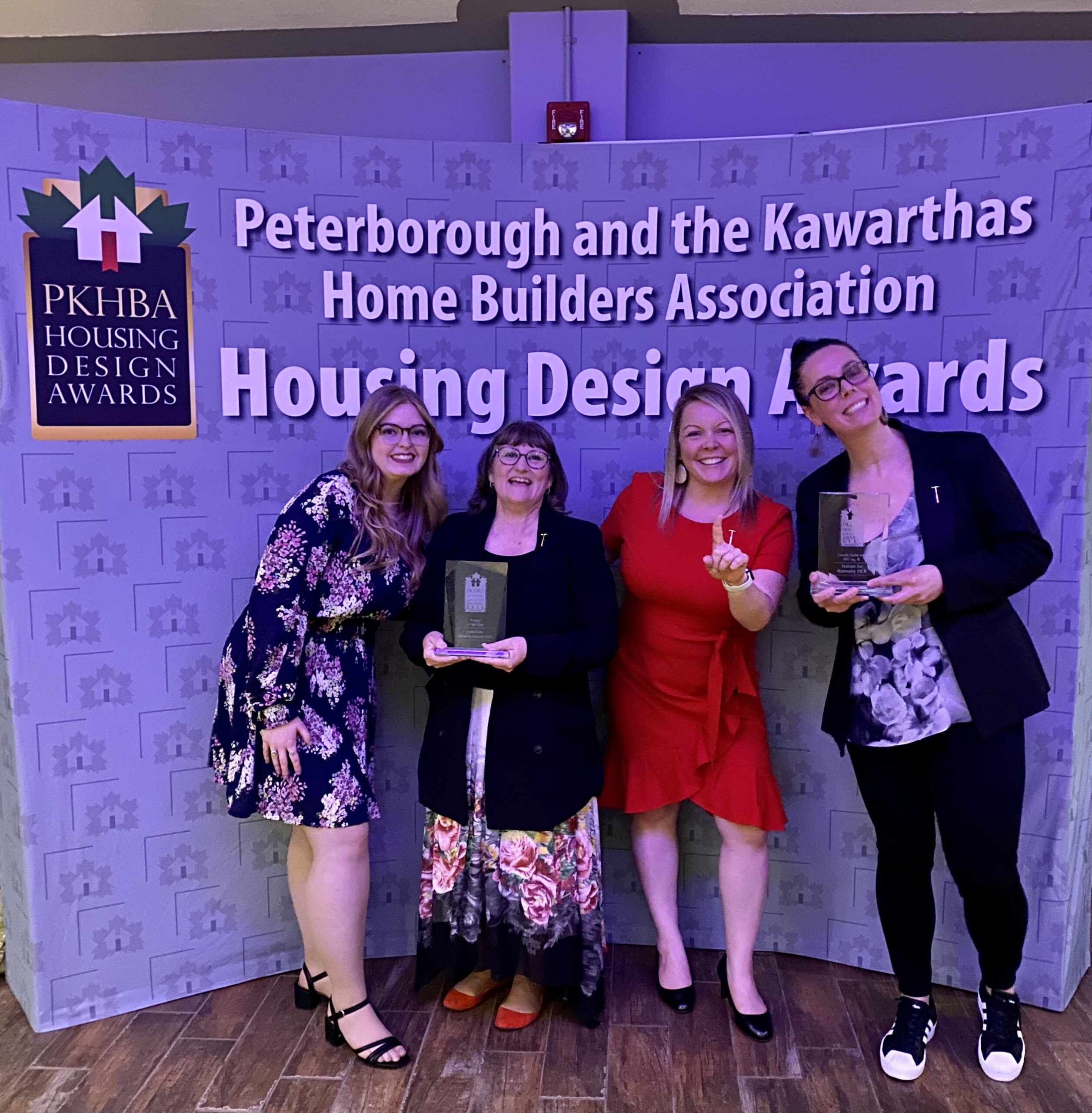 Habitat PKR Team (Jenn, Sue, Christina & Kylie) holding the award plaques won, in front of the PKHBA Housing Design Awards gala backdrop
