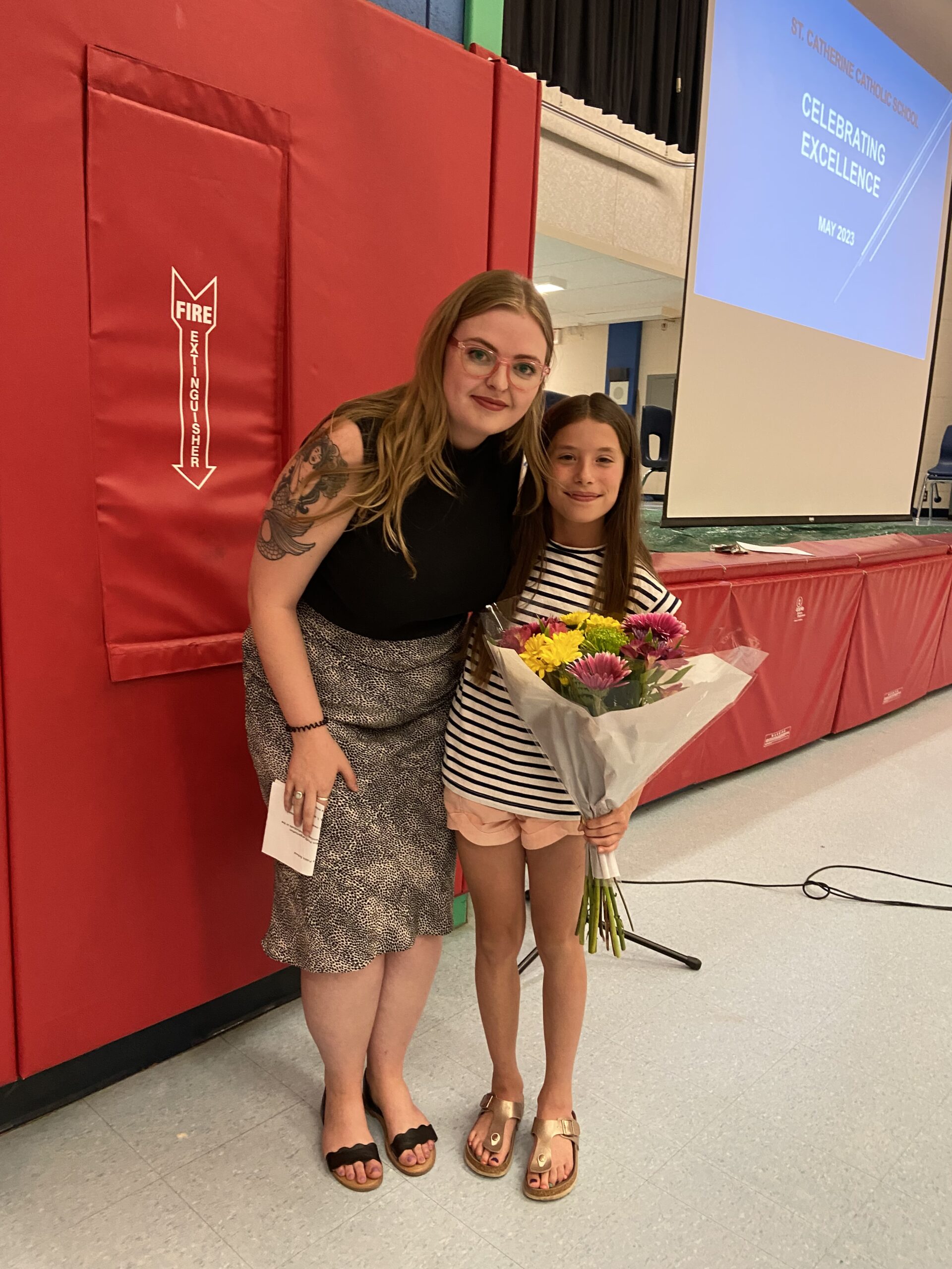 Habitat PKR Communications & Donor Services Manager Jenn MacDonald and Meaning of Home winner Ellyot Wood at the school assembly at St. Catherine Catholic Elementary School in Peterborough